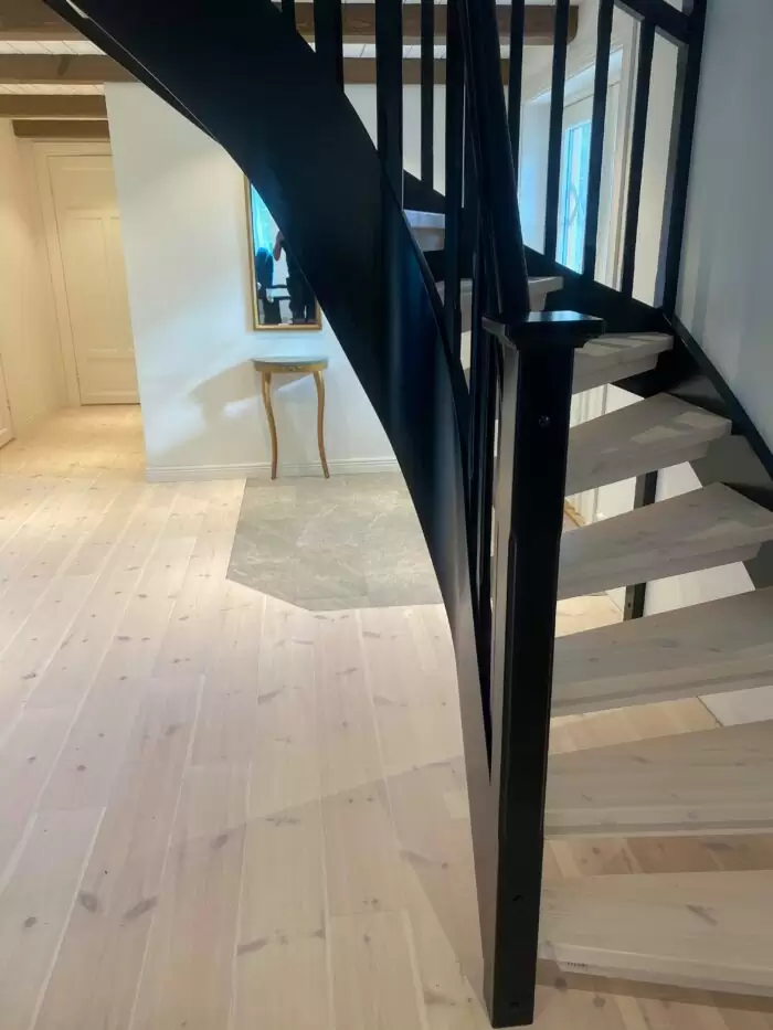 ljus trätrappa med svart räcke, modern